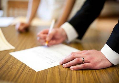 man signing a paper