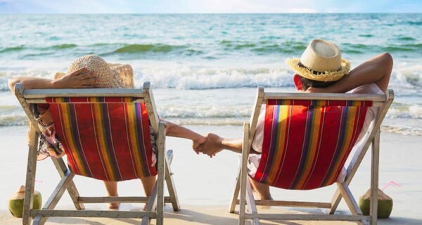 relax couple lay down beach chair with sea wave man woman have vacation sea nature concept