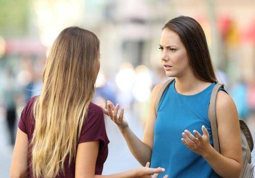 Two friends talking seriously on the street