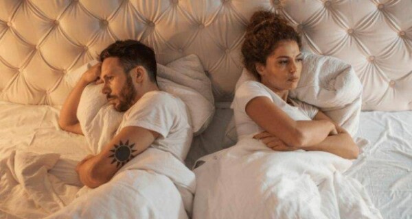 couple sleeping in separate directions leading to lack of passion in relationship