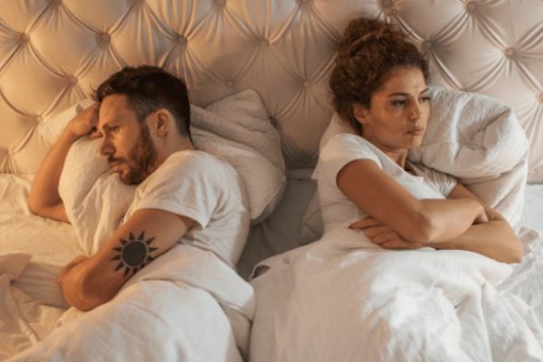 couple sleeping separate direction
