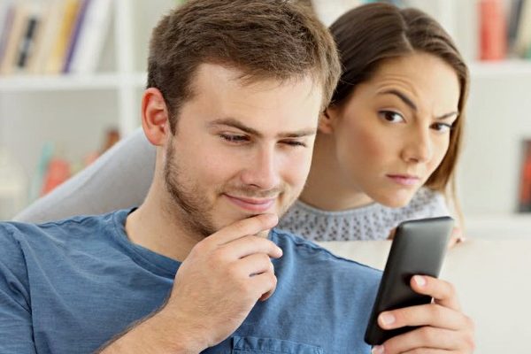woman stalking man with phone