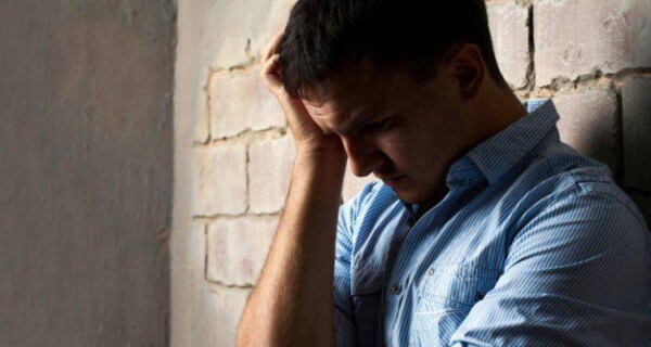 worried man standing near wall