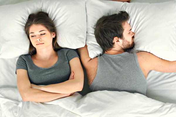 worried woman in bed with husband