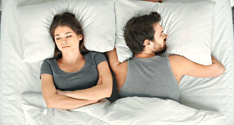 worried woman in bed with husband