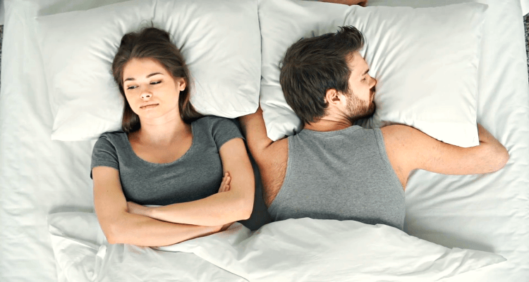 worried woman in bed with husband