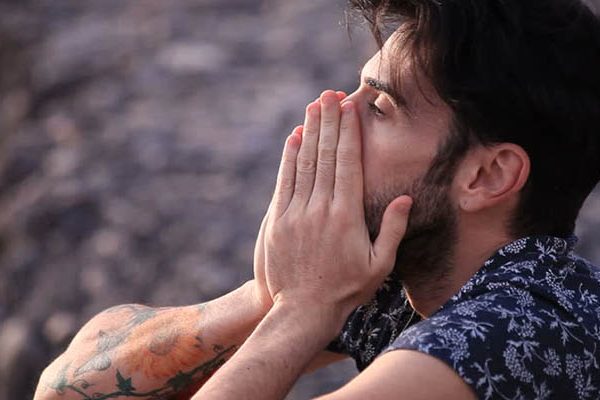 sad man hiding his face