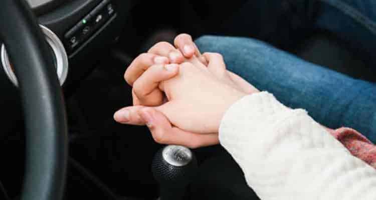 Couple holding hands in car