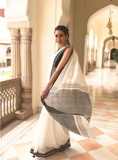 Karisma Kapoor in white-and-black cotton saree, with a pair of sliver jhumkas and bindi bloomed like summer rose