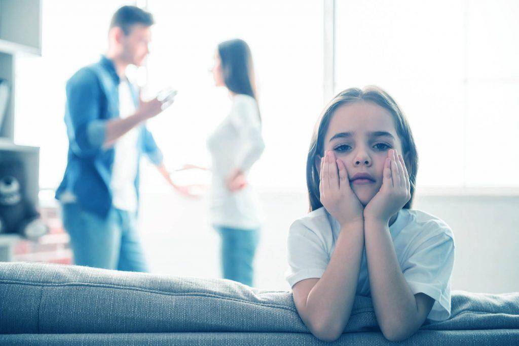 Daughter watching parents are arguing in the background