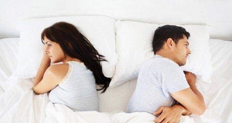 Couple not talking to each other in bed