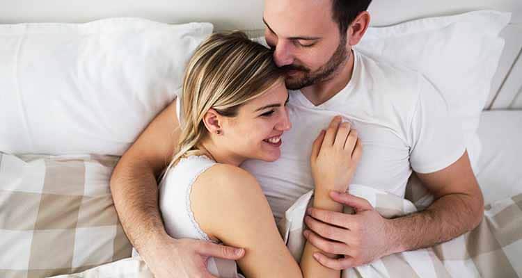 Couple cuddling in bed