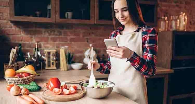 Girl looking on phone while cooking