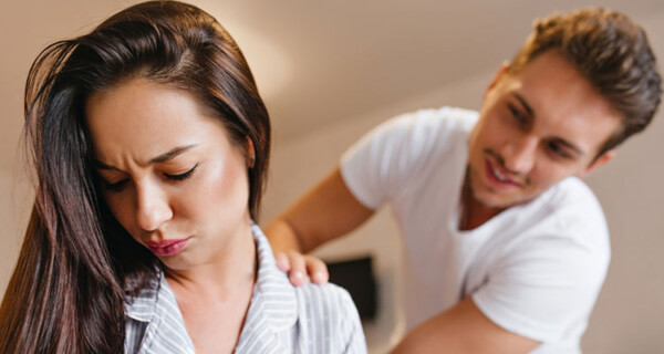 upset-brunette-woman-pajama-looking-down-while-husband-talk-her