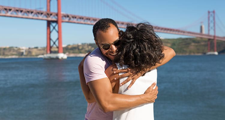 cheerful young couple hugging near river