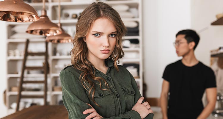 Beautiful upset woman with wavy hair holding hands together angrily