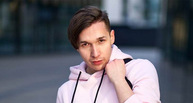 handsome young university or college student in pink hoodie