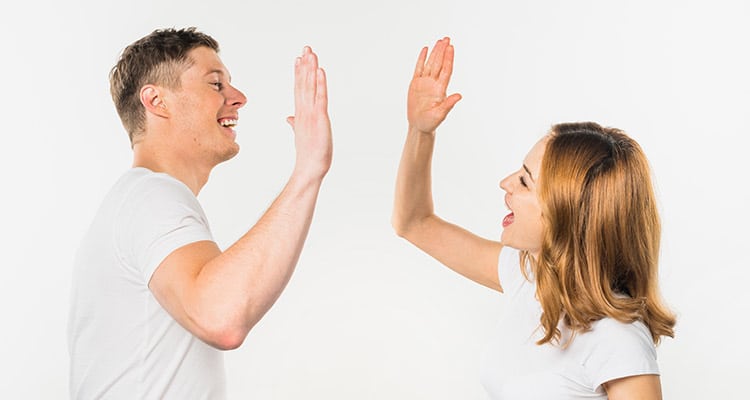 Smiling young couple giving high five to each other