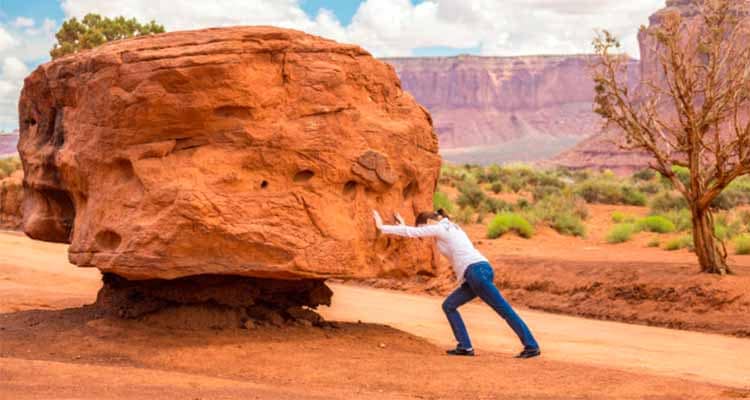 Girl pushing big stone hard