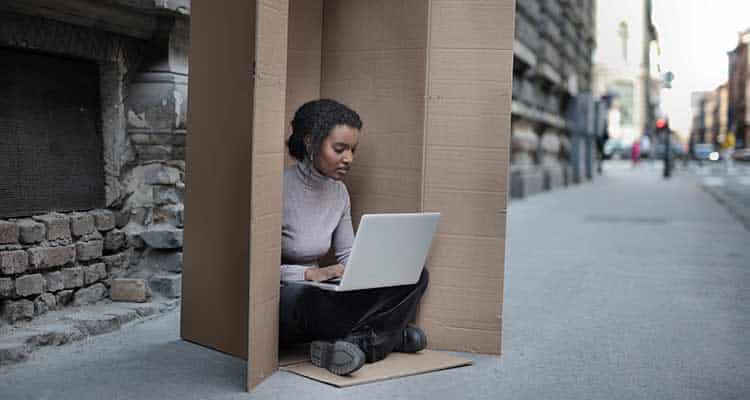 Woman working on laptop while sitting in the box