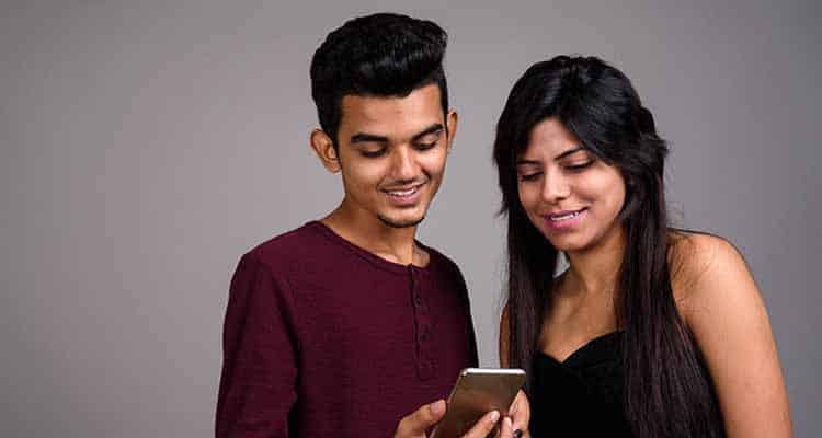 Young Indian college friends checking out photo in phone