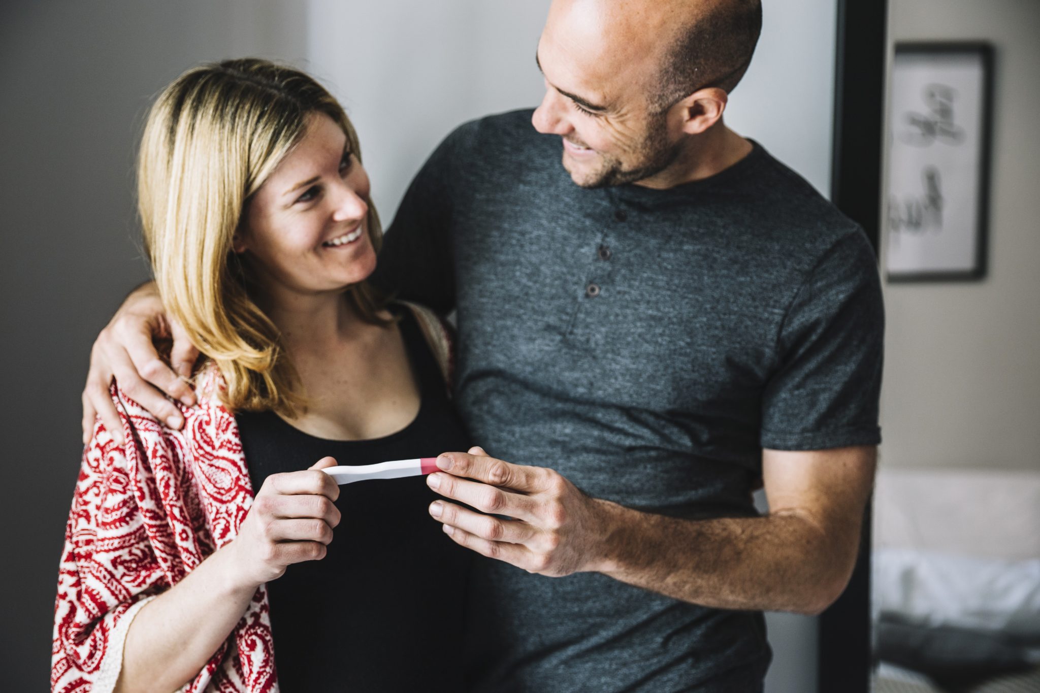 happy-woman-husband-looking-pregnancy-test